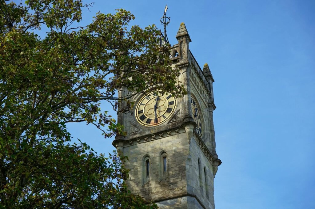 Old clock tower against a blue sky, from the era that explains why do we have daylight saving time