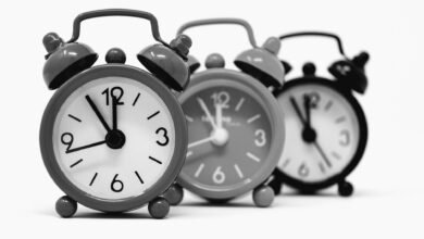 Three vintage alarm clocks, a symbol of why do we have daylight saving time and the twice-yearly clock change