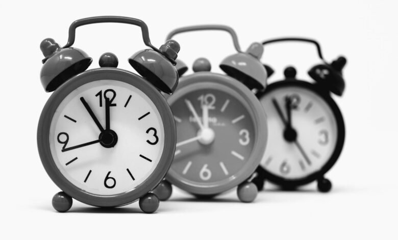 Three vintage alarm clocks, a symbol of why do we have daylight saving time and the twice-yearly clock change