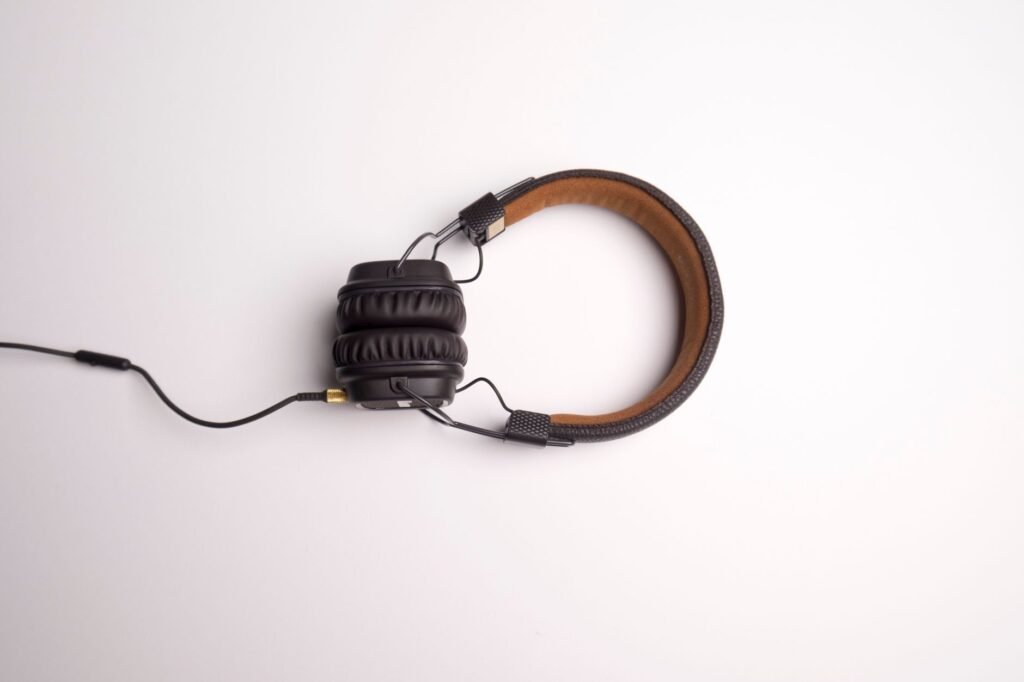 Headphones on a white background, a reminder of why do songs get stuck in your head after a recent listen