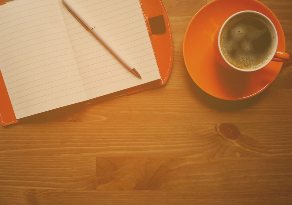 Notebook and pen beside a cup of coffee, a simple way to catch thoughts before they slip away