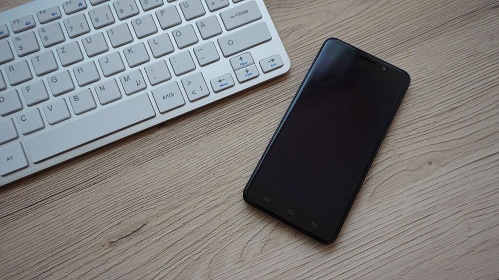 Smartphone beside a keyboard, because phone calls make it hardest to concentrate when someone is talking