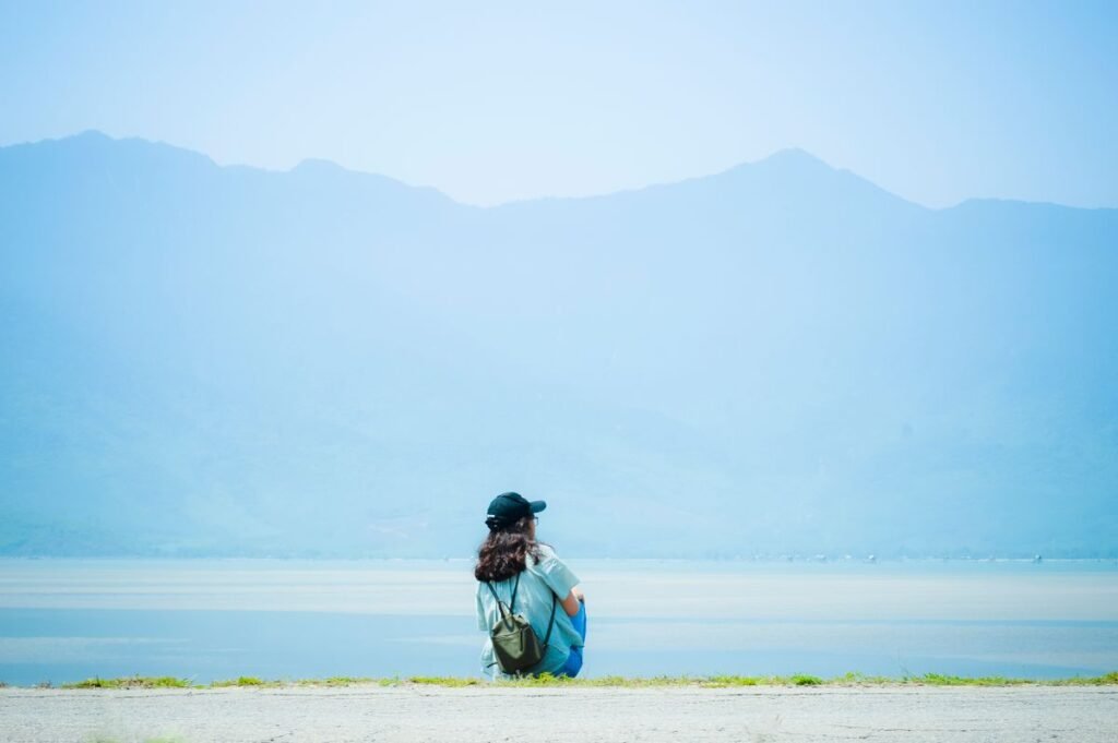 Person sitting alone in nature, the quiet feeling of being the last person on earth