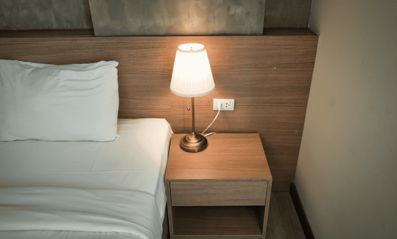 Bedside lamp glowing in a dark bedroom, the quiet scene when waking up at 3am
